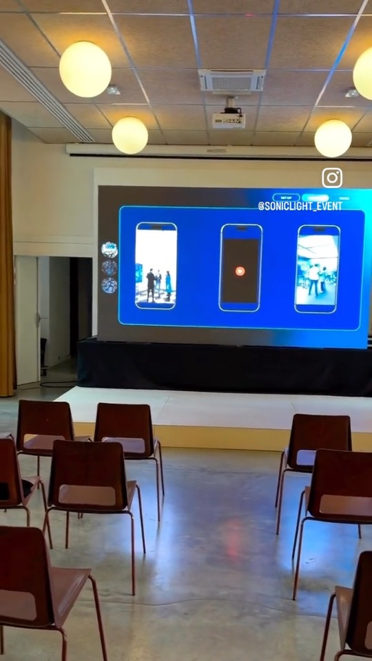 Salle de conférence Limitless Innovation avec mur de LED en fond de scène et rangées de chaises