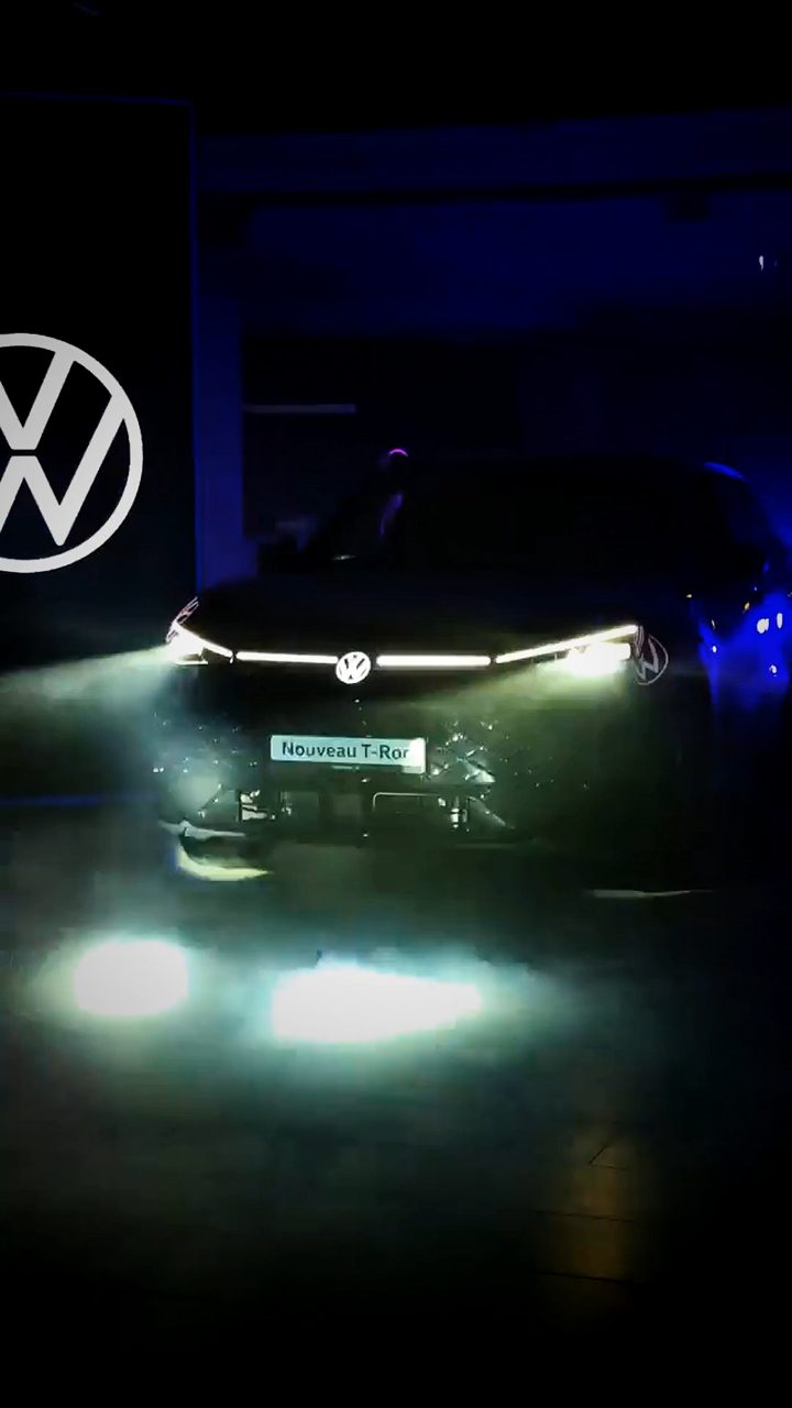 Véhicule Volkswagen phares allumés au moment de sa révélation, dans la fumée et les faisceaux de lumière
